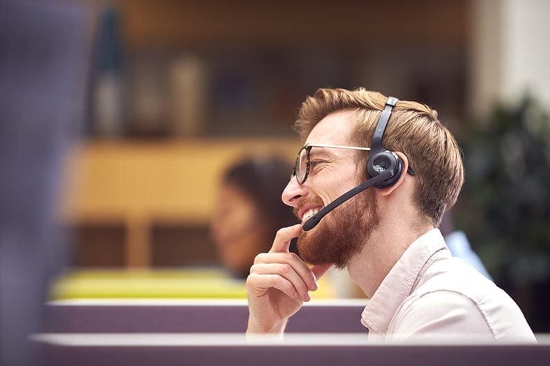 businessman-in-cubicle-wearing-headset-talking-to-2021-12-09-06-51-04-utc-scaled